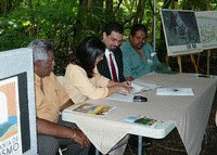 La directora ejecutiva de Turismo, Terestella González, firma el acuerdo. Le acompañan, desde su derecha, el alcalde de Humacao, Marcelo Trujillo, el subsecretario de Recursos Naturales; Javier Rúa y el director ejecutivo de PECES, José Oquendo. Firman acuerdo para desarrollar la Reserva Natural de Humacao en la primera área natural con ofrecimientos ecoturísticos